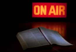 A bible and broadcast on-air sign symbolising a Christian radio or television broadcast or podcast or media event.